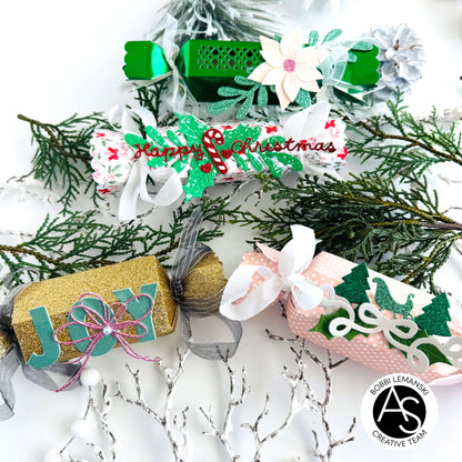 Christmas-themed gift boxes with decorative ribbons and text on a festive background.Alex_Syberia_Christmas_Cracker_die and christmas Jokes stamp