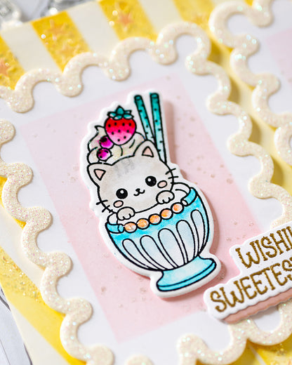 A close-up of a handmade greeting card featuring a cute white kitten in a blue milkshake with a strawberry on top, surrounded by scalloped glittery borders - Sweet treats alex syberia designs stamp