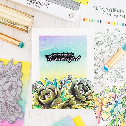 Coloring book with floral design and 'you are absolutely wonderful' text, surrounded by coloring supplies.alex-syberia-designs-lush-peony-pressplate-cardmaking in the uk-cardmaking supplies-best