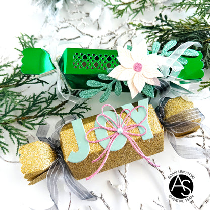 Christmas-themed gift boxes with decorative ribbons and text on a festive background.Alex_Syberia_Christmas_Cracker_die and christmas Jokes stamp