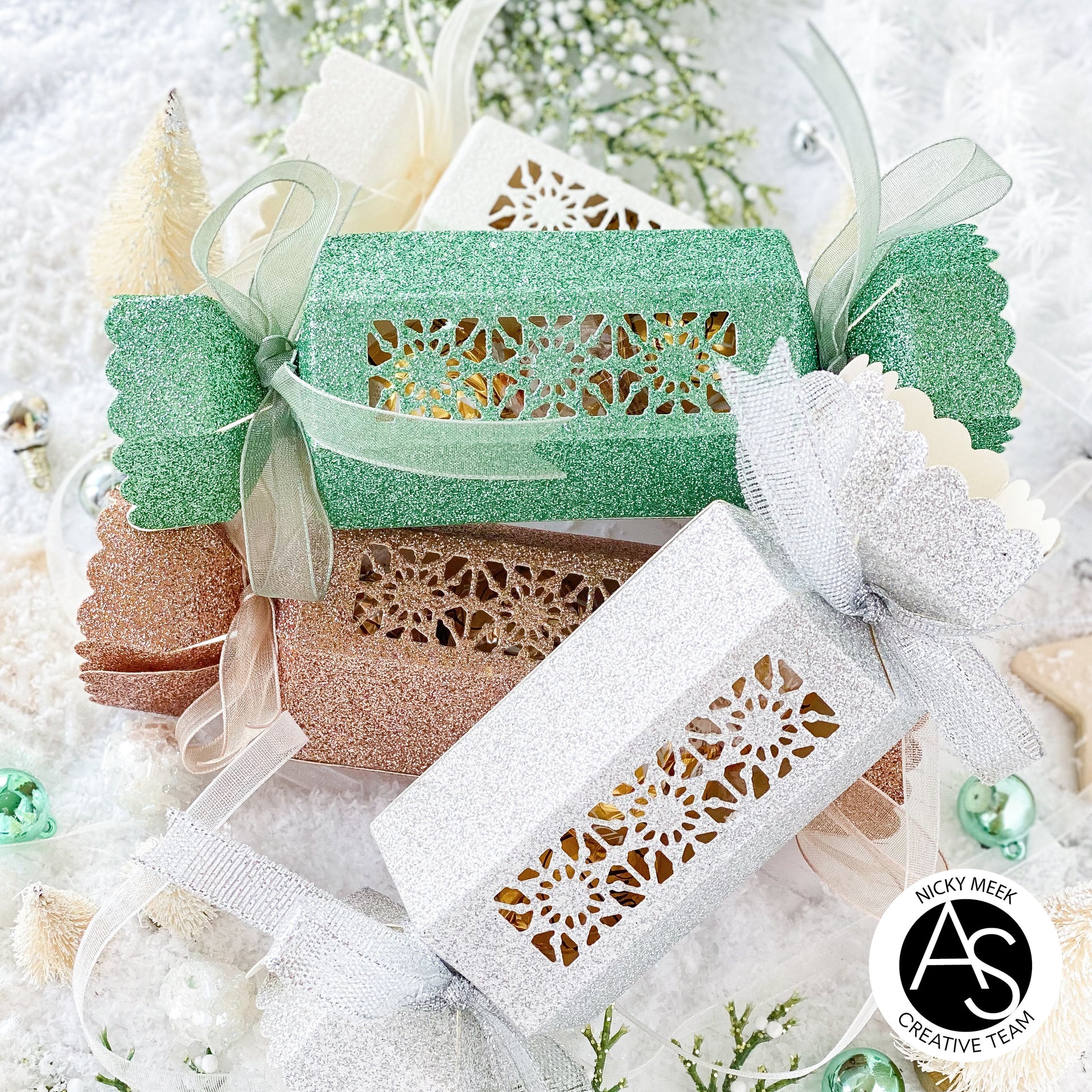 Christmas-themed gift boxes with decorative ribbons and text on a festive background.Alex_Syberia_Christmas_Cracker_die and christmas Jokes stamp